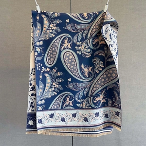 Close-up of navy blue paisley jacquard shawl showing thick texture and tassel fringe