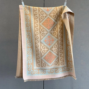 Detail of geometric floral pattern on soft ginger yellow and blue tassel scarf shawl