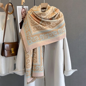 Detail view of jacquard floral scarf with fringes styled on a white coat and brown handbag