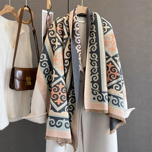 Minimalist geometric pattern scarf with fringe, draped over a beige wool coat in autumn style