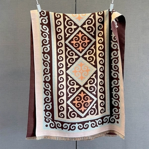 Detail of geometric pattern knit scarf with vintage floral motifs and fringe edges