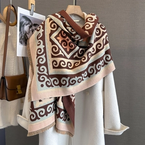 Detail of warm winter shawl with geometric patterns and fringe edges on a coat