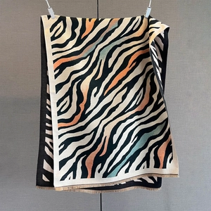 Detail of soft cashmere feel shawl featuring artistic zebra patterns and fringe edges