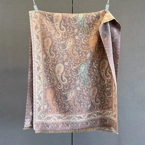 Detail of pink paisley cashmere feel shawl featuring elegant fringe and ethnic patterns