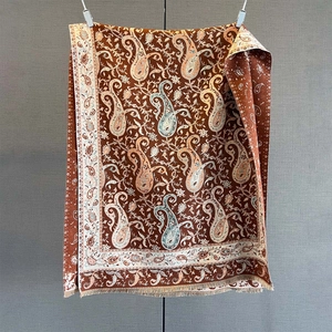 Close-up of paisley pattern and tassel trim on warm cashmere-feel pashmina shawl