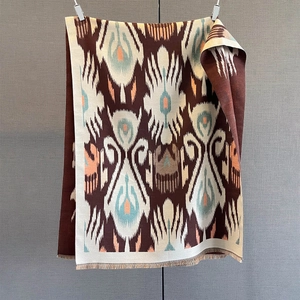 Detail of ethnic geometric pattern and fringe trim on a thick bohemian shawl scarf