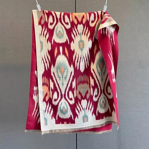 Detail of red paisley scarf showing thick fabric texture and beige fringe tassels