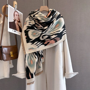 Detailed view of bohemian ikat pattern winter scarf with soft fringes and warm texture