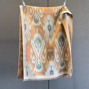 Detailed view of an ikat pattern cashmere scarf with decorative tassels and fringe