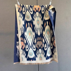 Detail of cashmere feel scarf with ikat pattern and fringe tassels for winter warmth