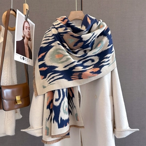 Detail of cashmere feel scarf with geometric paisley pattern on a white coat