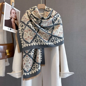 Winter floral jacquard scarf with tassels draped over a white coat for elegant style
