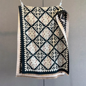 Detailed view of bohemian floral print scarf with intricate tassels and woven texture