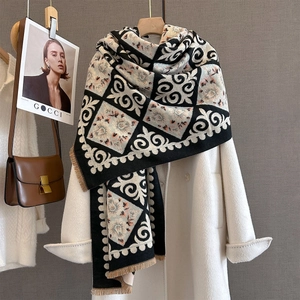 Detailed view of paisley and geometric pattern cashmere-feel scarf with elegant fringes
