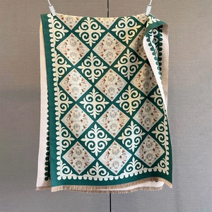 Close-up of forest green paisley pattern scarf with thick fringe and jacquard texture