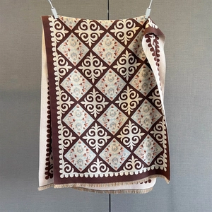 Close-up detail of cashmere-feel scarf with vintage diamond patterns and fringe edges