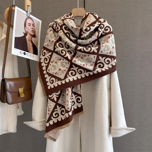 Detail of cashmere feel scarf showing paisley pattern, fringe edges and thick texture