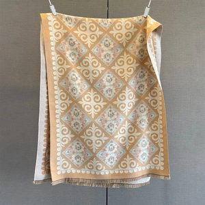 Detailed view of warm orange cashmere feel shawl with paisley pattern and tassel fringe