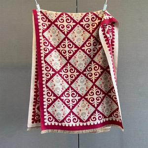 Macro detail of red and beige jacquard scarf with retro geometric patterns and tassels