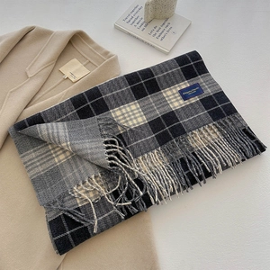 Close-up of thick checkered scarf with long tassels and soft knitted texture