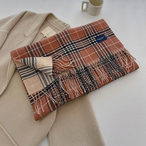 Close-up of retro plaid scarf texture with Elegant & Classic woven label and soft tassels