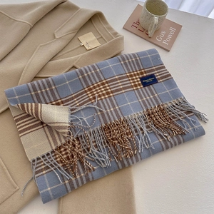Detail of blue and brown plaid tassel scarf with a soft cashmere texture and elegant finish