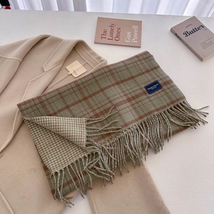 Close-up of classic checkered scarf with soft fringe and Elegant & Classic woven label