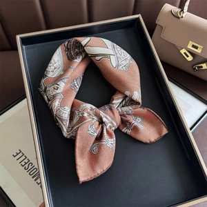 Vue détaillée du carré de soie noué en nœud avec des motifs vintage de calèche