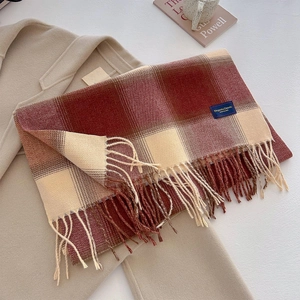 Close-up of red plaid thick scarf texture with elegant woven label and long fringe