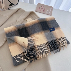 Close-up of classic checkered scarf with soft fringe and 'Elegant & Classic' label detail