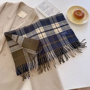 Detail of plaid scarf fringe and Elegant Classic label on a cozy autumn coat