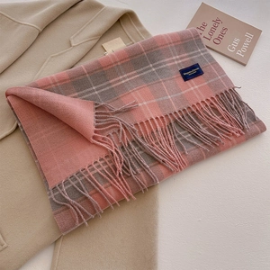 Close-up of pink grey plaid scarf with soft tassels and Elegant & Classic woven label