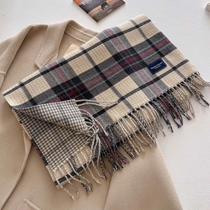 Detail of plaid scarf featuring fringed edges and Elegant and Classic woven label
