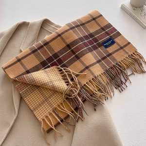 Detail of classic plaid scarf with fringe and 'Elegant & Classic' label on wool coat