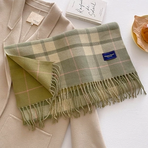 Classic green plaid scarf with long tassels on beige coat with elegant vintage vibes