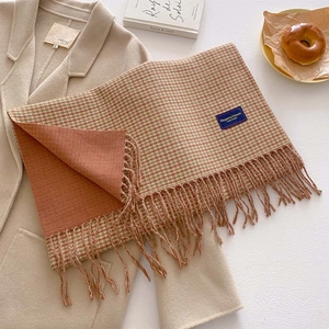 Detailed view of houndstooth scarf with elegant long fringes and premium woven label
