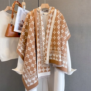 Dettaglio dello scialle in maglia jacquard geometrico con frange sottili color caramello