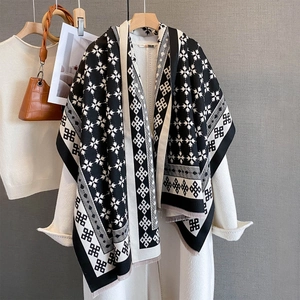 Dettaglio dello scialle jacquard bianco e nero con motivo a stelle e bordi a frange