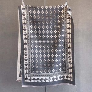 Dettaglio della sciarpa invernale grigio scuro con jacquard floreale beige e frange