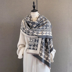 Dettaglio sciarpa jacquard grigia e beige con motivi a fiocco di neve e frange fini
