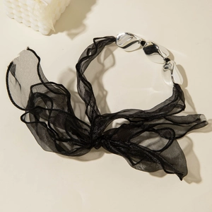 Close-up of black mesh ribbon necklace with three large silver metallic beads