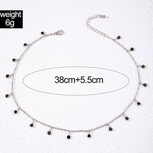 Detail view of dainty silver tassel necklace with black beads and length measurements