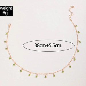 Detail view of gold tassel necklace with green beads, measuring 38cm plus 5.5cm extension