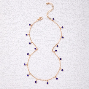 Detail of gold chain necklace with blue faceted crystal beads and lobster clasp closure