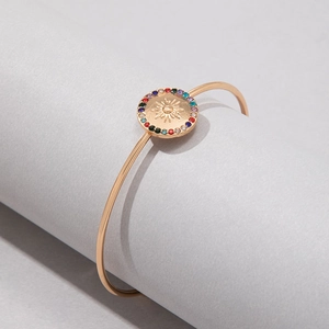 Détail du bracelet fleur soleil doré avec incrustations de pierres colorées