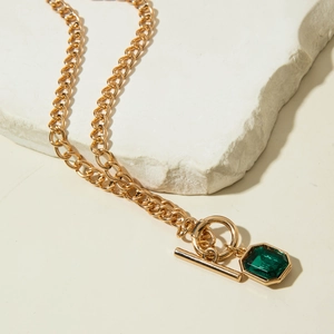 Détail du collier à chaîne dorée avec pendentif taille émeraude et fermoir à bascule OT