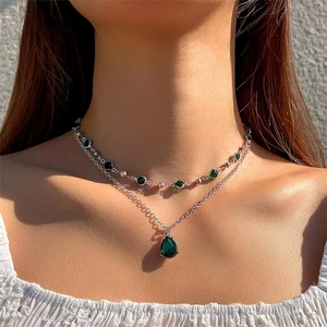 Détail du collier argenté à deux rangs avec cristaux vert émeraude ronds et en poire