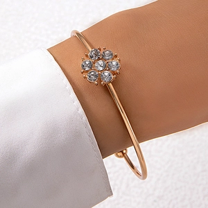 Détail d'un bracelet manchette doré orné de fleurs en strass étincelants de qualité
