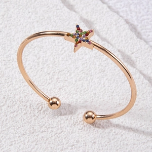 Vue macro d'un bracelet ouvert or rose avec un motif d'étoile en cristaux colorés