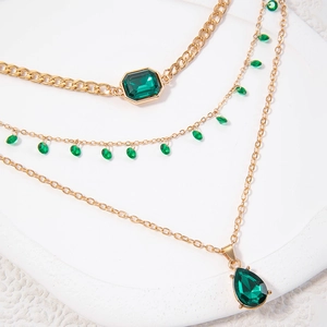Drielagige gouden kettingset met smaragdgroene edelstenen en een stoere Cubaanse stijl
